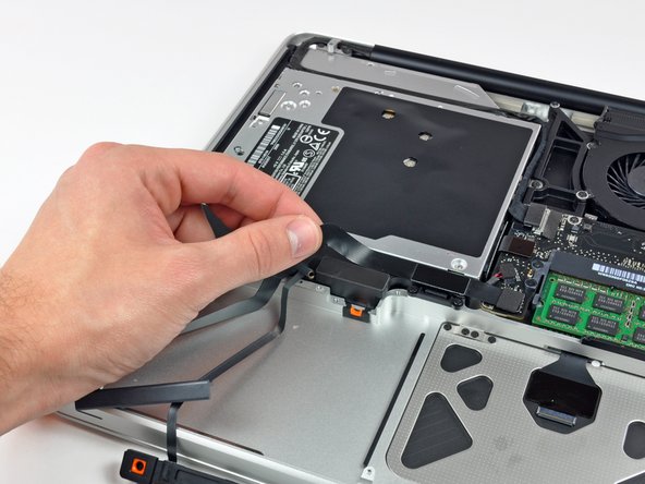 Image 2/2: Carefully peel the hard drive and IR sensor cable from the upper case.