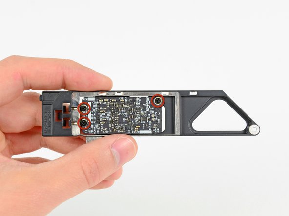Image 1/2: Use the flat end of a spudger to dislodge the AirPort/Bluetooth board from its recess in the AirPort/Bluetooth board housing.