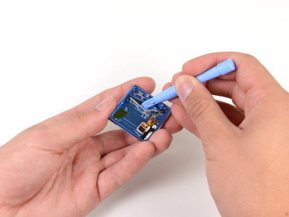 We begin prying the headphone jack ribbon cable assembly from the inner case. Unfortunately, what seems to be an entire bottle of glue slows our process.