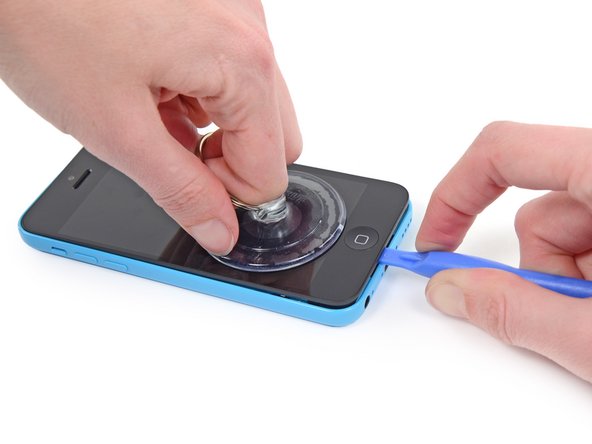 Image 1/2: While holding the iPhone down with one hand, pull up on the suction cup to slightly separate the front panel assembly from the rear case.