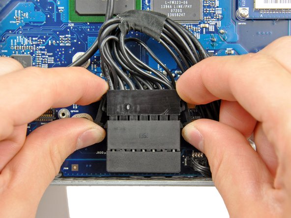 Image 2/2: After both locking arms pass their retaining tabs, it is helpful to push the arms toward the top edge of your iMac while wiggling the connector.