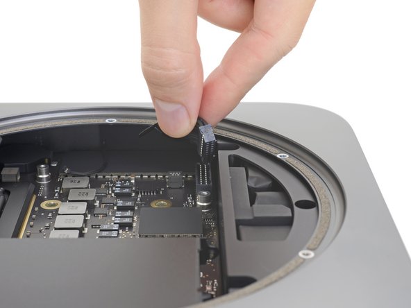 Grasp the power supply cable and lift to disconnect it from the logic board, wiggling as needed to loosen it up.