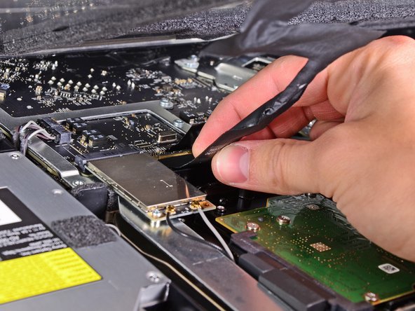 Image 2/2: Do not lift up on the display data cable, as its socket is very fragile. Pull the cable parallel to the face of the logic board.