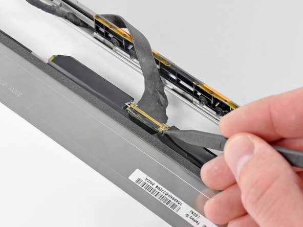 Image 1/2: Pull the display data cable straight away from its socket on the LCD.