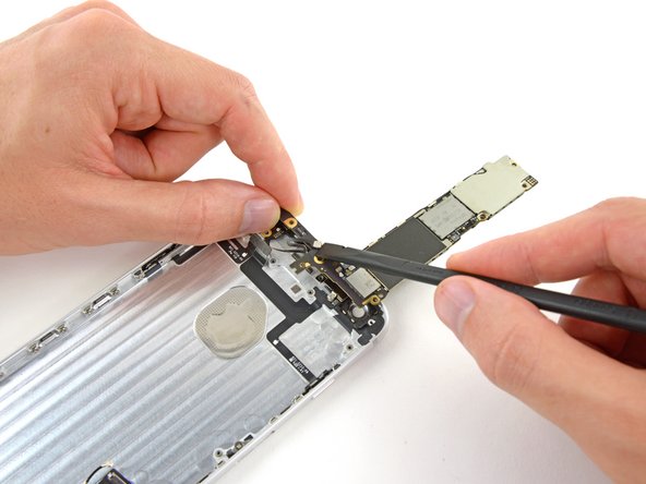 Image 1/2: Use the flat end of a spudger to disconnect the antenna connector from its socket on the back of the logic board.