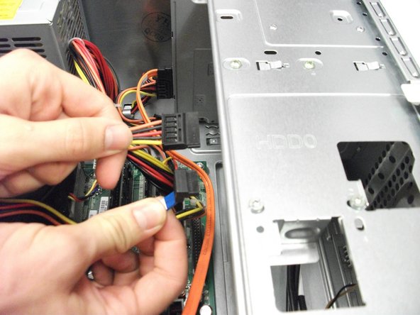 Image 1/1: Locate and remove the two cables connected to hard drive.