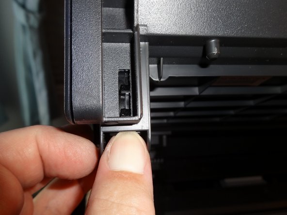 Press the tab to release the clips, then when it's out gently pull towards you to release the back