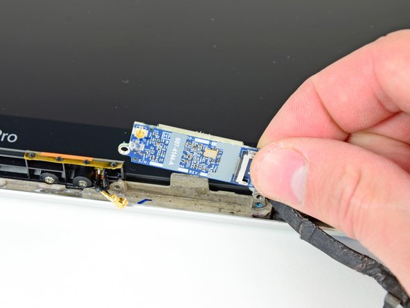 Image 2/2: Before installing a new AirPort card, be sure the thermal material on its surface is intact and aligned with the small heat sink on the display frame.