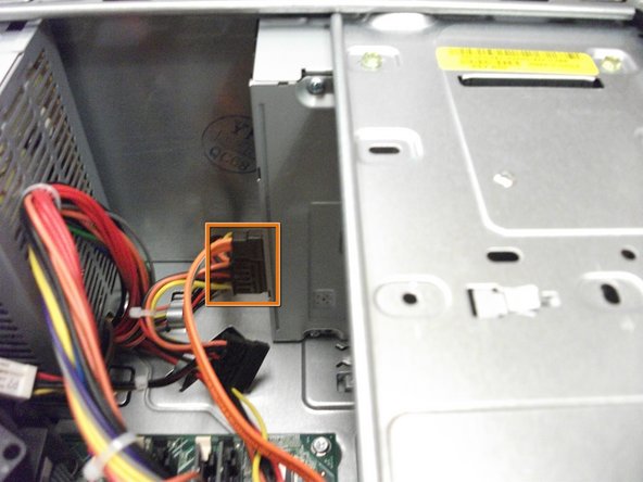 Image 1/1: Locate and remove the two cables attached to the CD/DVD drive.