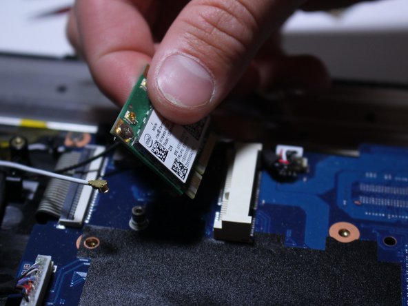 Now grab the Wi-Fi card and slowly pull it up and outward as shown in the photos.