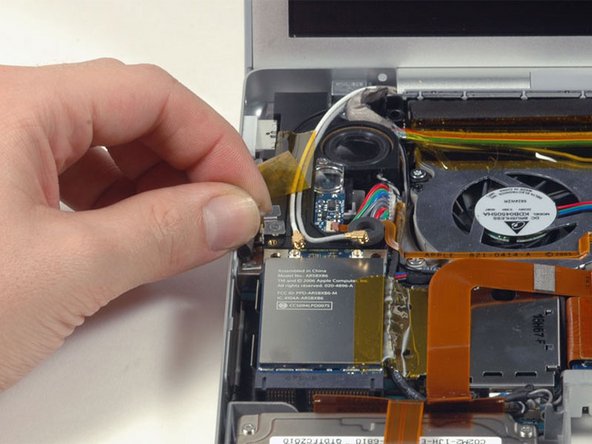 Image 1/1: Peel back the orange tape on the right side of the Airport Extreme card.