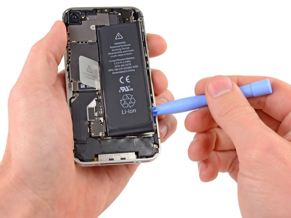 Insert the edge of a plastic opening tool between the battery and the outer case near the bottom of the iPhone.