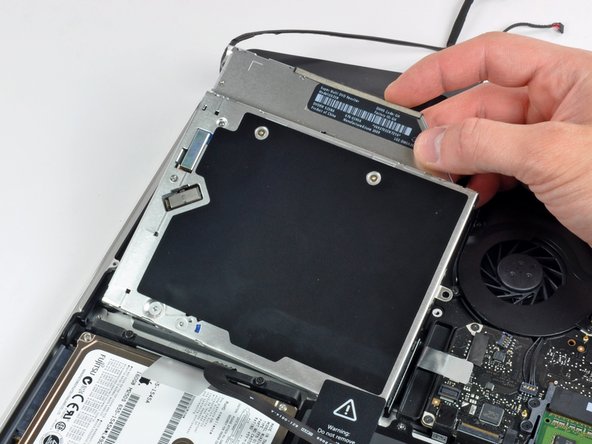 Image 2/2: Lift the optical drive from its right edge and pull it out of the computer.