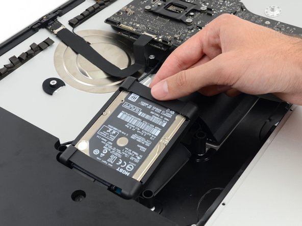 Image 2/3: The hard drive is attached by two cables, do not attempt to fully remove it from the iMac.