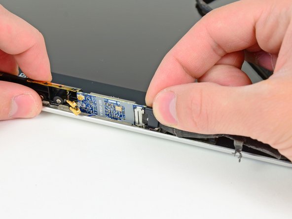 Image 1/2: Remove the camera cable retainer.