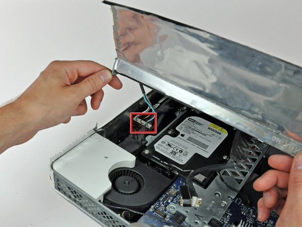 Image 1/1: Disconnect both inverter cables (shown in red) by pulling their connectors toward the bottom edge of your iMac.