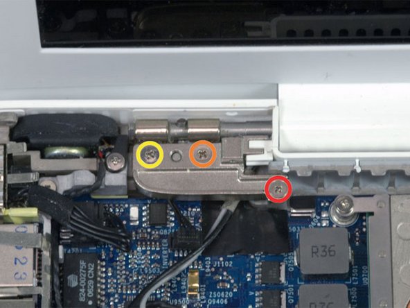 Hold the display with one hand while removing the screws from the left hinge mount.