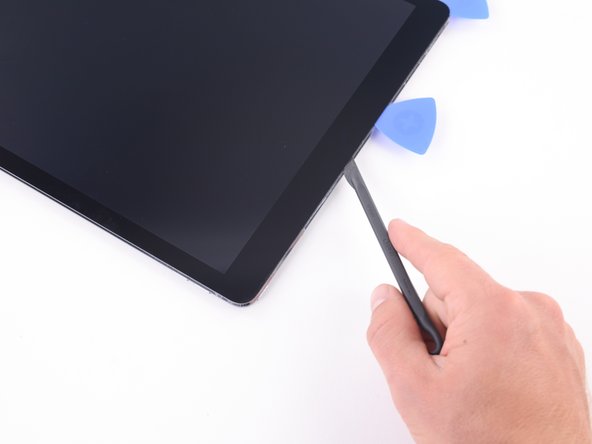 Insert the blade of the halberd spudger just past the front-facing camera, on the opposite side of the opening pick.