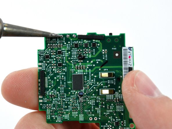 To open the solder holes, open a safety pin and push it against the solder blocking the hole. At the same time, heat the same solder pad from the other side of the logic board. Opening the holes completely will require repeating this procedure several times from alternating sides of the logic board.