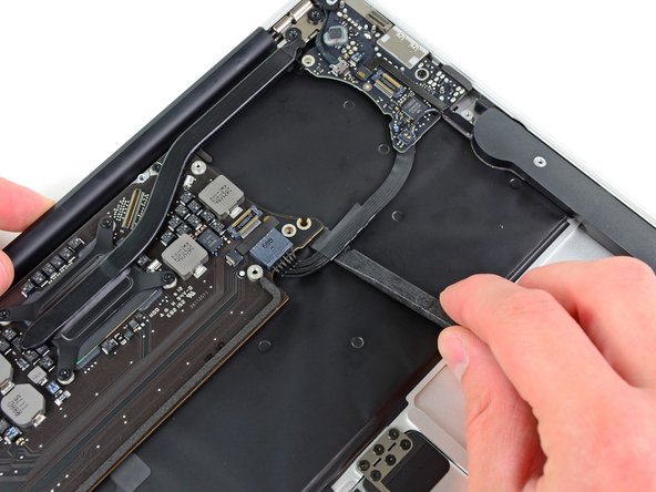 Image 1/2: Pull the cable parallel to the face of the logic board toward the front edge of the Air.