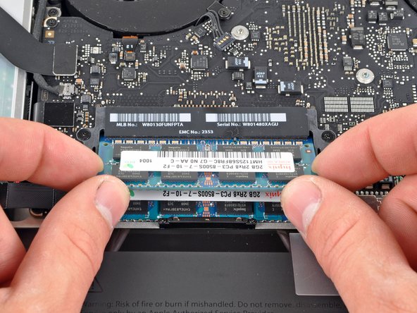 Image 2/3: After the RAM chip has popped up, pull it straight out of its socket.