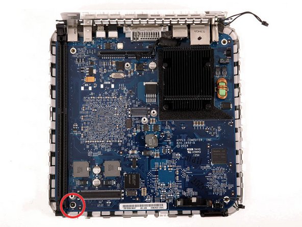 Remove the single black Phillips screw from the front left corner of the logic board.