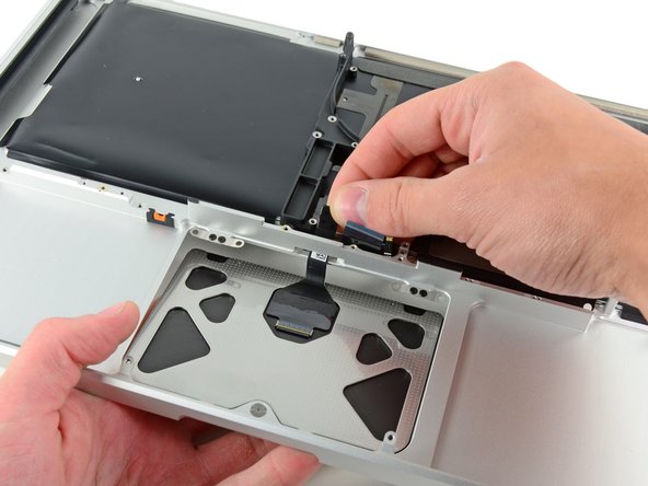 Image 1/1: De-route the trackpad cable through its slot cut into the upper case.