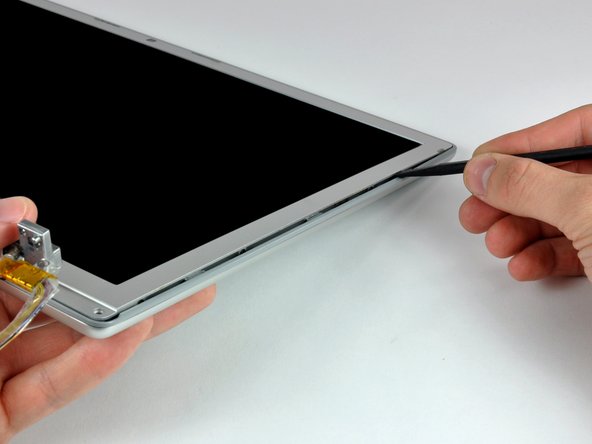 Image 3/3: Work along the right edge of the display until the rear bezel is evenly separated from the front bezel.