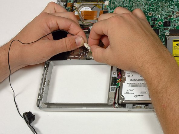 Image 2/2: De-route the right speaker cable and remove the speaker from the computer.