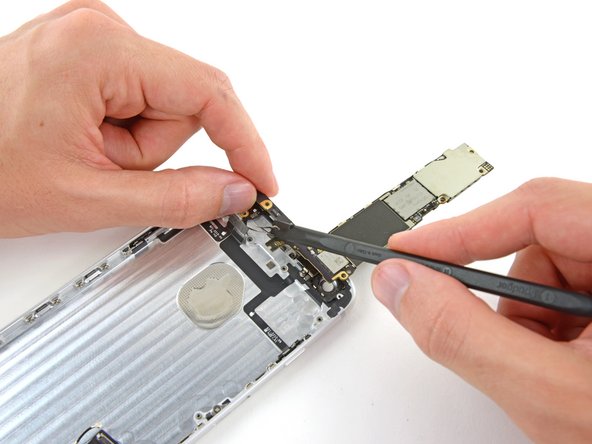 Image 2/2: Use the flat end of a spudger to disconnect the antenna connector from its socket on the back of the logic board.