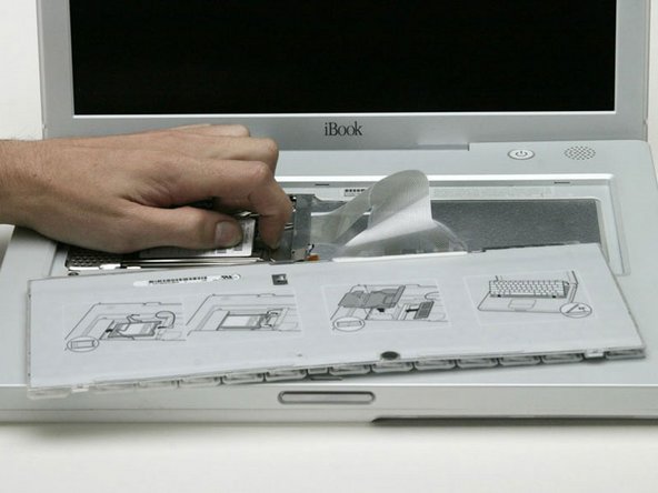 Image 1/1: Push the wire clasp toward the AirPort card and pull it up to free it from the RAM shield.