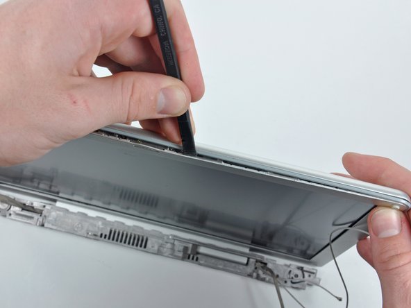 Image 2/2: Work along the top edge of the display until the rear bezel is evenly separated from the front bezel.