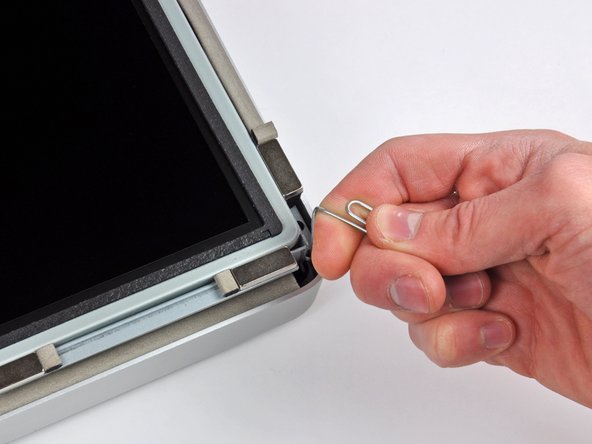 Image 2/3: Use a thin hooked tool to lift one side of the top edge of the display by its steel outer frame.