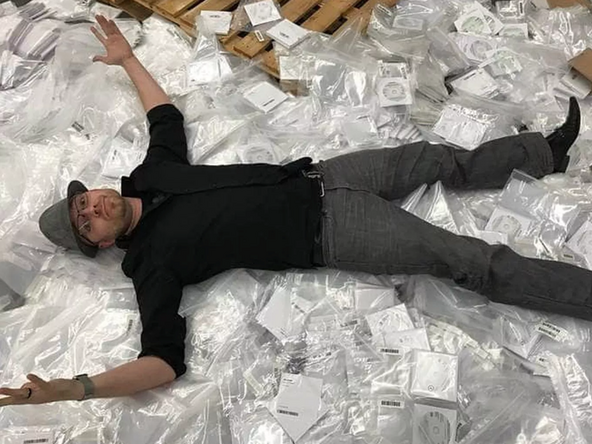 Eric Lundgren lays on a stack of Dell restore discs