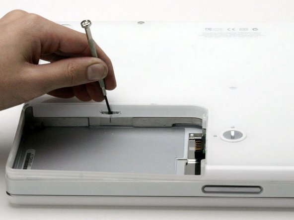 Image 1/1: Use a small flathead screwdriver to pry out the slot's lower rim and pull up on the lower case to free the slot from the tabs holding it.