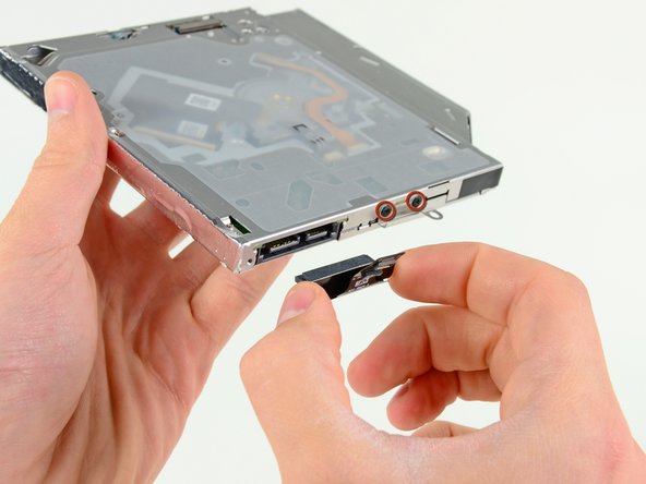 Image 2/2: Remove the two black Phillips #0 screws securing the small metal mounting bracket. Transfer this bracket to your new optical drive or [product|IF107-080|hard drive enclosure].