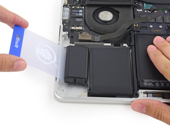 Image 1/3: Gently pry the left-most battery cell up from the upper case.