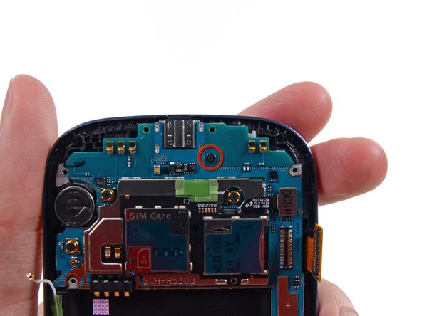 Image 1/1: Remove the single 3.0 mm Phillips #0 screw securing the motherboard to the front panel assembly.