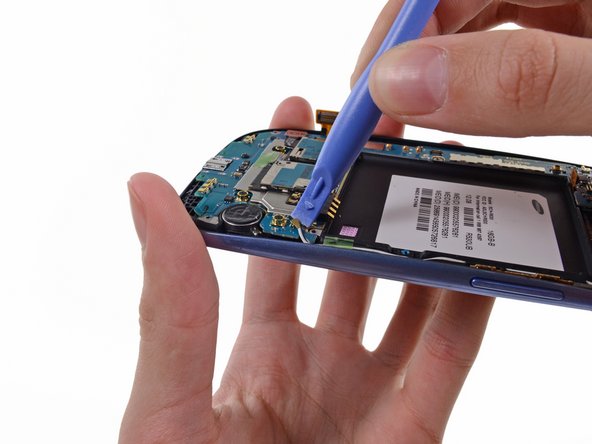 Image 1/3: Pry the Wi-Fi antenna cable connector up from its socket on the motherboard.