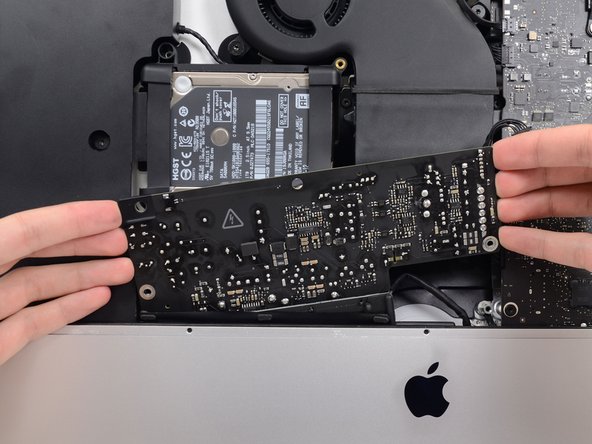 Image 3/3: Rotate the power supply counterclockwise, lifting the right side up about an inch higher than the left.