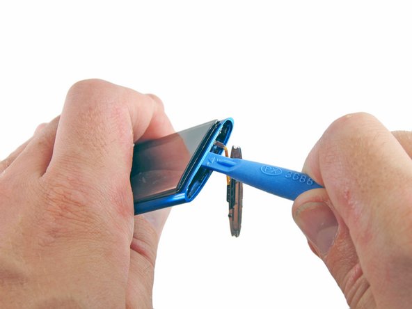 Image 2/2: Rotate the iPod opening tool towards the rear of the device, slightly lifting the top of the glass out of the outer case.