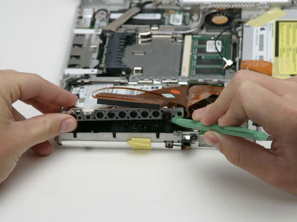 Image 1/1: Peel back the black tape to free the microphone cable from the hard drive.
