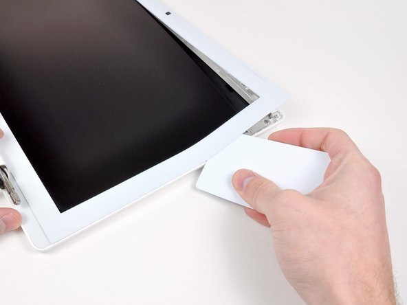 Next, free the five tabs securing the display bezel on the right side.