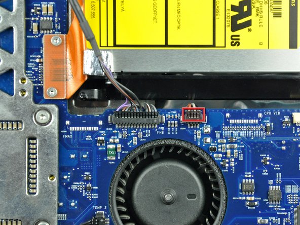 Image 1/2: To aid in removal, it is helpful to use both of your thumbnails to push the ears on either side of the connector toward the top edge of the iMac.