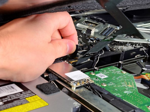 Image 1/3: Pull the display data cable straight out of its socket on the logic board.