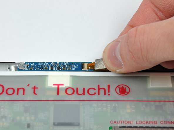 Image 1/2: Pull the display data cable connector away from its socket on the LCD.