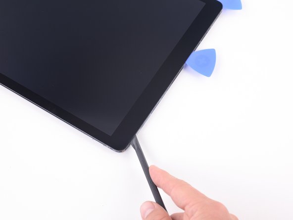 Continue to slide the blade of the halberd spudger to the upper right corner of the iPad.