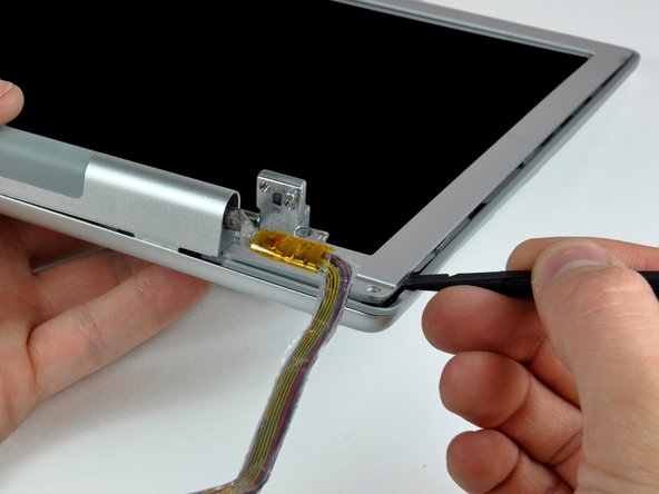 Image 2/2: Pry the rear bezel away from the front bezel to slightly separate the bottom edge of the rear display bezel.
