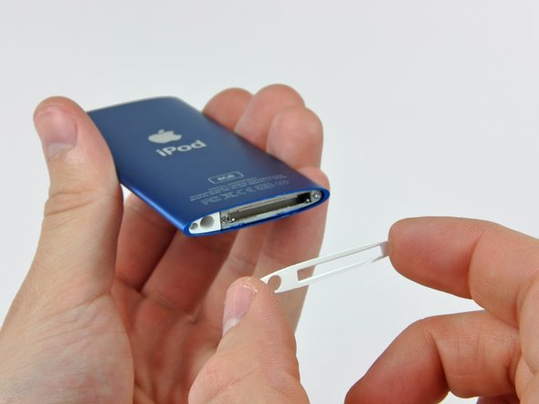 Image 2/2: Separate the bottom bezel from the adhesive securing it to the Nano and set it aside.