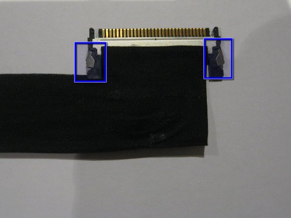 Image 2/2: Press '''IN''' the 2 silver spring loaded catches on either side to release the cable and gently extract it from the connector